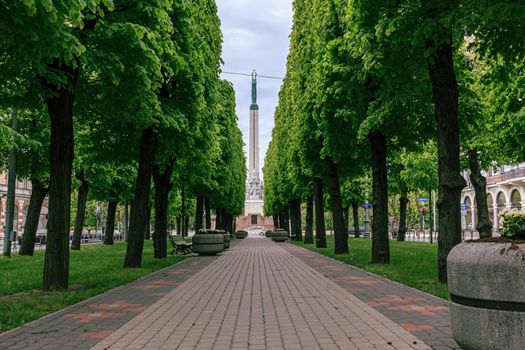 Riga, Latvia: June 1, 2020: the monument of freedom, standing women with tree stars in hands, perspective view from city street park