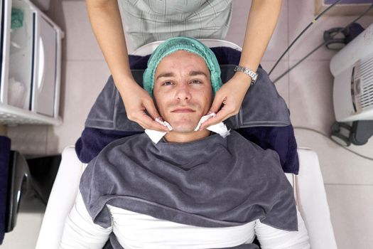 Top view of a patient lying down on a stretcher reaady for a facial beauty treatment