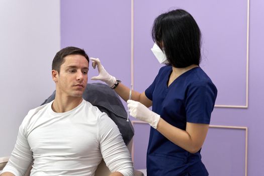 Doctor explaining the procedure of a facial beauty treatment using collagen injection to a patient.