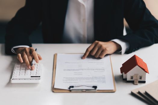 Close up of Business woman pointing and signing agreement for buying house. Bank manager concept