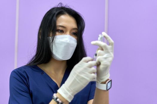 Focus on the serious face of a doctor preparing a injection of collagen for a facial rejuvenation treatment