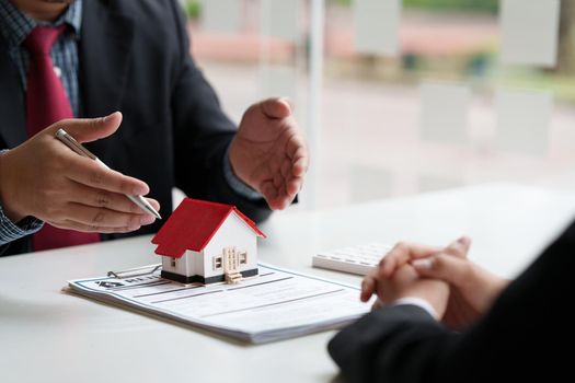 Close up of Business man pointing and signing agreement for buying house. Bank manager concept