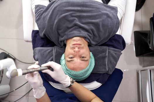 Top view of a man lying on a stretcher prepared to receive intraoral laser rejuvenation treatment.