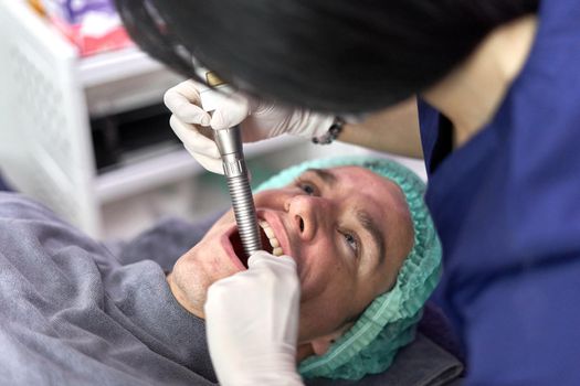 Close up view of the face of a man receiving a beauty treatment with laser in a clinic