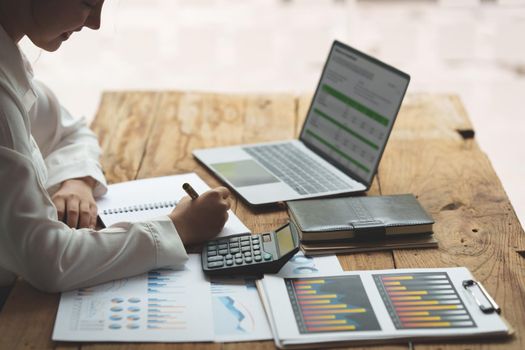 Close up Business woman hand using calculator to calculate the company's financial results and budget. Account Audit Concept