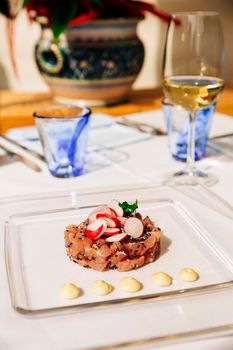 Tuna tartare, a preparation of finely chopped raw meat or fish with a knife, sesame, wasabi and radishes.