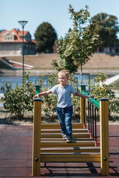 A full-length portrait of a little boy in a striped sailor shirt in the port city of Klaipeda.