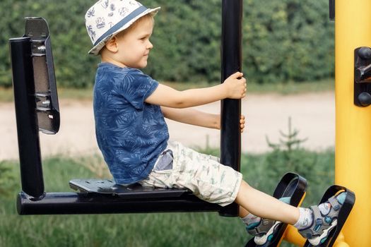 Boy athlete on outdoor sports ground. Child boy is exercising on playground.