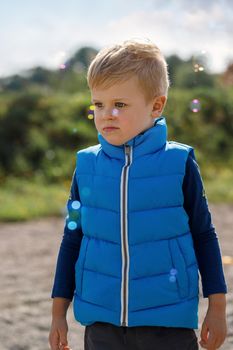 Games with children in nature, in the fresh air in summer. A child and soap bubbles in the outdoors.