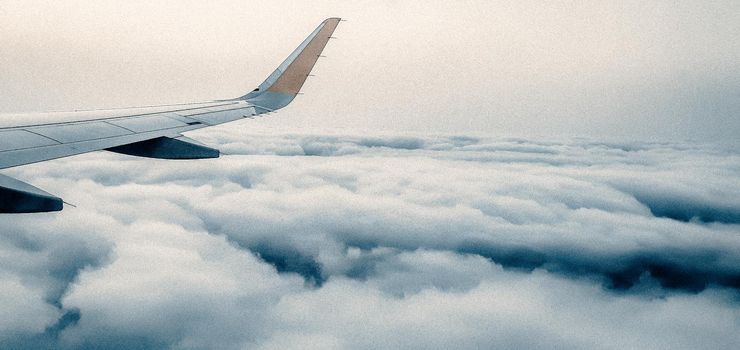 Flying above fluffy clouds on a plane for summer vacation, AERIAL