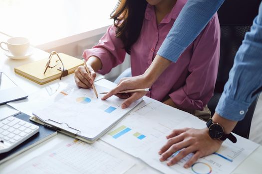 negotiation, analysis, discussion,asian male economist pointing out a document explaining the investment finance program to the company owner to plan marketing and hedging business risks