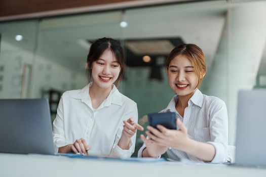 financial, Planning, Marketing and Accounting, portrait of Asian woman Economist using calculator to calculate investment documents with partners on profit taking to compete with other companies.