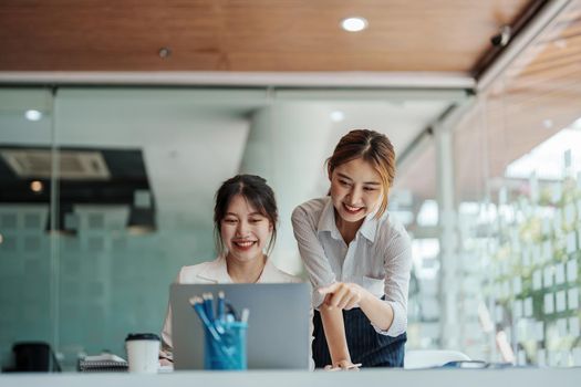 financial, Planning, Marketing and Accounting, portrait of Asian woman Economist using computer and investment documents with partners on profit taking to compete with other companies.