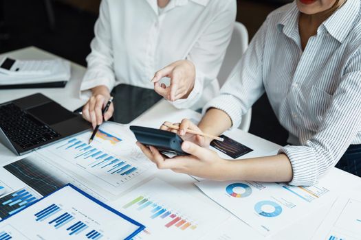 financial, Planning, Marketing and Accounting, portrait of Asian woman Economist using calculator to calculate investment documents with partners on profit taking to compete with other companies.