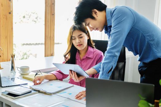 negotiation, analysis, discussion,asian male economist using tablet explaining the investment finance program to the company owner to plan marketing and hedging business risks