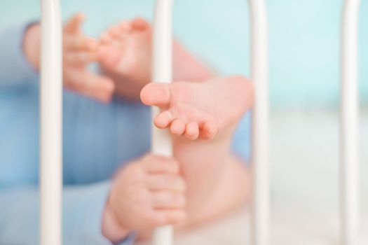 Feet and heels of a four months old baby lying on the bed at home