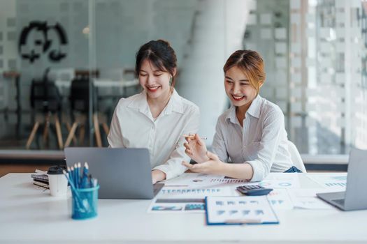 financial, Planning, Marketing and Accounting, portrait of Asian woman Economist using computer and investment documents with partners on profit taking to compete with other companies.