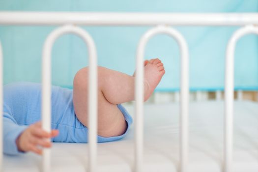 Feet and heels of a four months old baby lying on the bed at home