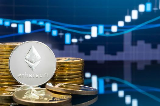 Ethereum (ETH) and cryptocurrency investing concept - Physical metal ethereum coins with global trading exchange market price chart in the background.