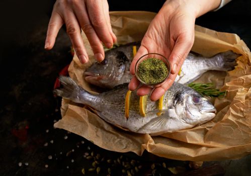 Raw dorado fish with spices cooking on cutting board.