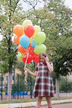 Teenage girl with colorful helium air balloons having fun outdoors. Tween Party. enjoying summer.