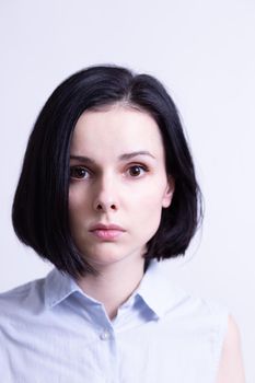 woman in a blue sleeveless office shirt, light background. High quality photo