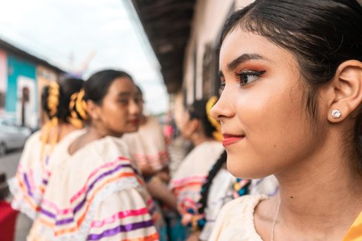 Latin young woman dressed in traditional costume of Nicaraguan folklore with her group of friends in the background in Leon Nicaragua