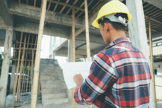 Asian man Engineer Stand and look at the work at the construction site, architecture inspector