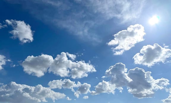 Bright sunny day, blue sky with snow-white different types of clouds