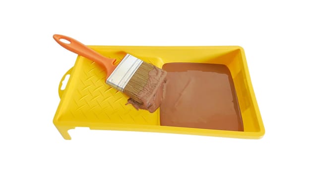 Yellow tray of green paint with brush on white background