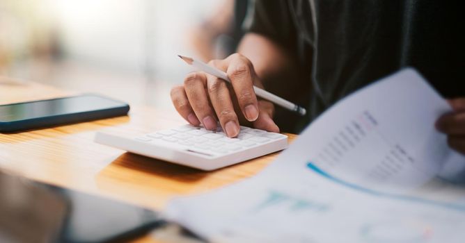 Close up hand of accountant working with computer and calculator for business and financial expense