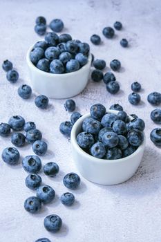 Fresh blueberries background with copy space. Blueberry antioxidant organic superfood in bowls concept for healthy eating and nutrition. Harvesting concept. Vegan Vegetarian