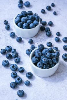 Fresh blueberries background with copy space. Blueberry antioxidant organic superfood in bowls concept for healthy eating and nutrition. Harvesting concept. Vegan Vegetarian