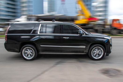 Ukraine, Kyiv - 26 April 2021: Black Cadillac Escalade car moving on the street. Editorial