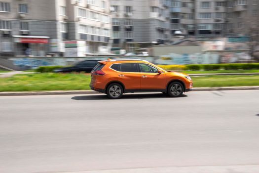 Ukraine, Kyiv - 26 April 2021: Orange Nissan Rogue car moving on the street. Editorial