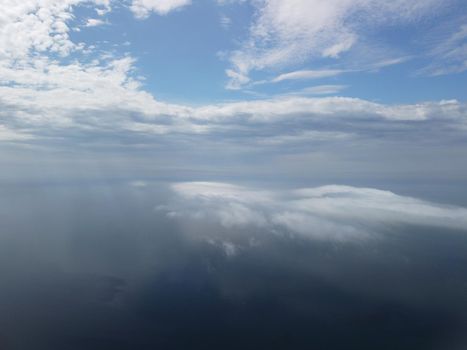 Footage B roll Aerial view drone flying above white clouds dense fog move quickly. Drone flies high back in blue sky through fluffy clouds. Beautiful foggy and cloudy slow moving Aerial view. Fog sea.