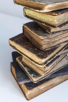 Old books stacked on top of one another, with a white background.