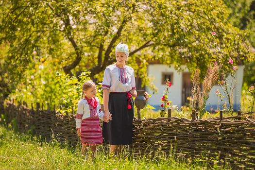 mother and daughter in Ukrainian national costumes are walking on the street