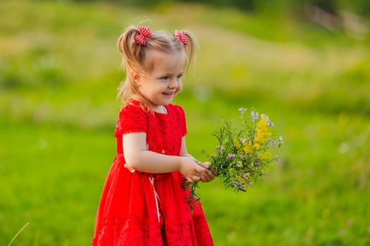 girl in a red dress and flowers on the lawn