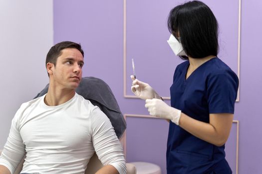 Patient and doctor talking before start a collagen treatment to rejuvenate the skin in a clinic