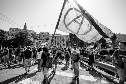 Ventimiglia, Italy, 14.07.2018: People who protest with anarchy flag during an anti-racist demonstration in Ventimiglia.