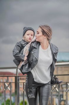 mother carries her daughter on her back while walking around the city