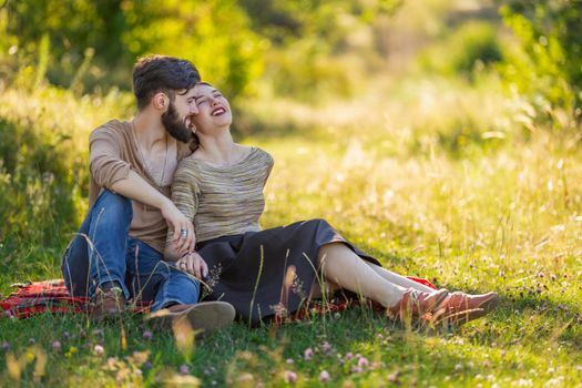 young couple sitting in summer garden