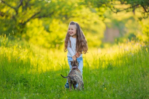 girl playing with a dog in nature