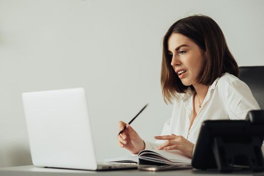 Confident Young Woman Working at Office by Laptop, Female Manager Writing Notebook at Workplace