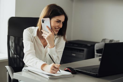 Female Employee Working at Office, Woman Note Message While Making a Phone Call on Smartphone
