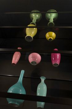 Antique colored vases placed on top of the glass shelves