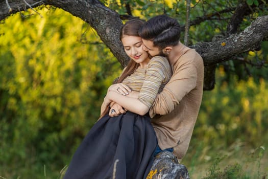 young couple hugging near a tree