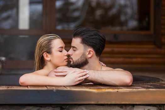 portrait of a couple kissing in a tub of water