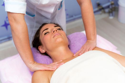 Facial massage. A woman is given a massage in a beauty salon. Close-up.